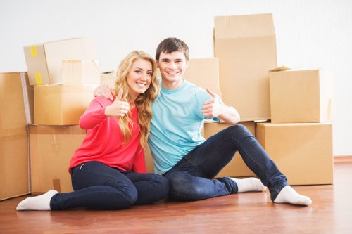 Movers carrying furniture through a Holloway home